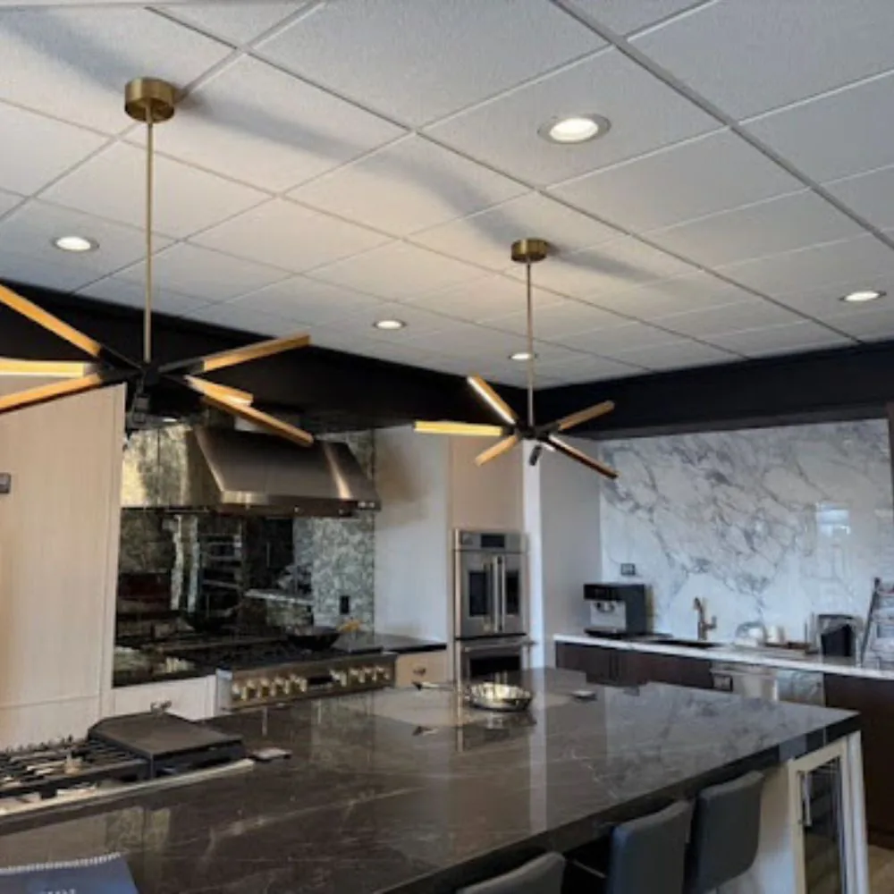 Kitchen showroom with gold pendant lights over the island and recessed ceiling lights