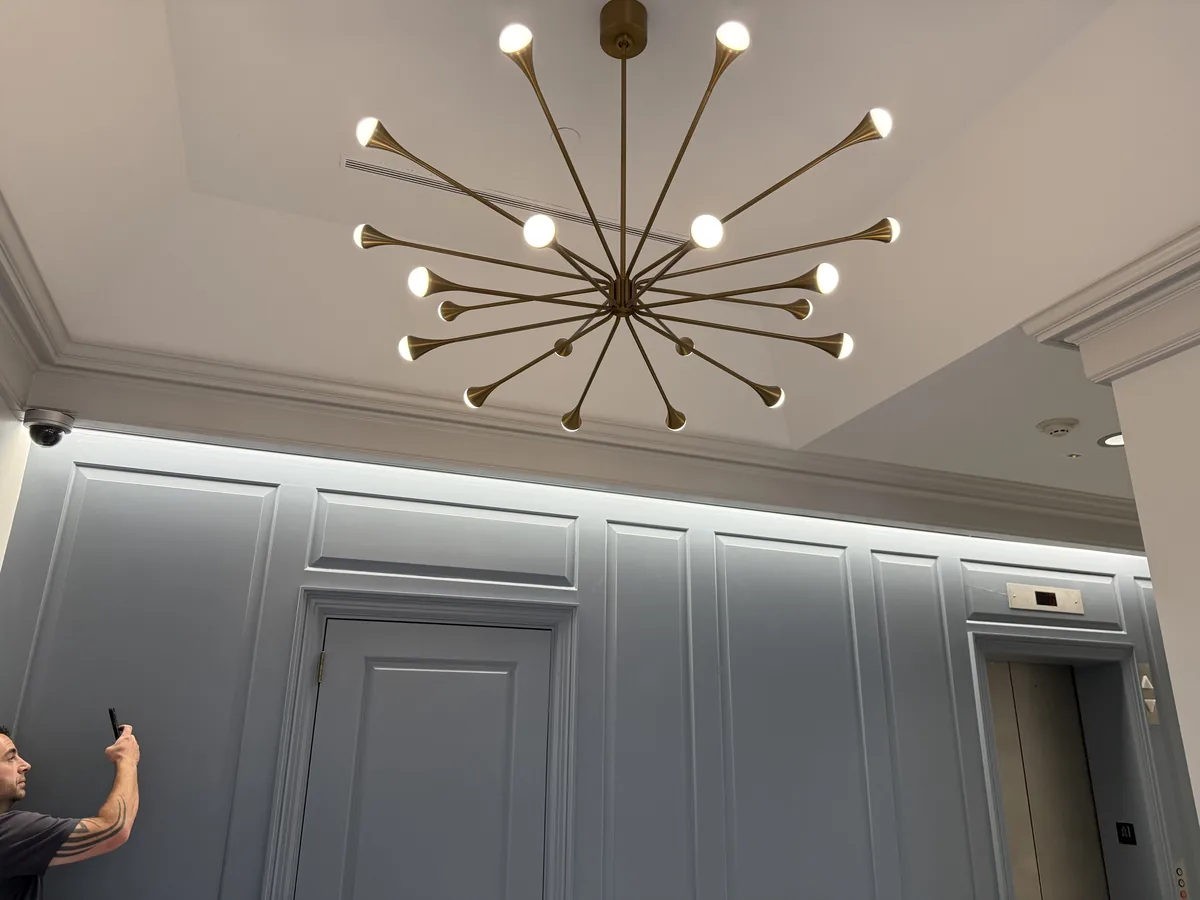 Modern sputnik-style chandelier installed in a commercial lobby ceiling